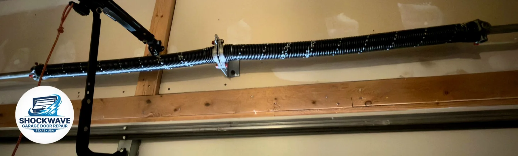 Two black torsion springs mounted above a residential garage door in Shockwave's Austin-area work gallery.